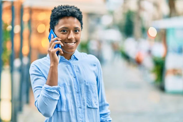 若いアフリカ系アメリカ人の女の子が笑顔で市内のスマートフォンで話しています — ストック写真