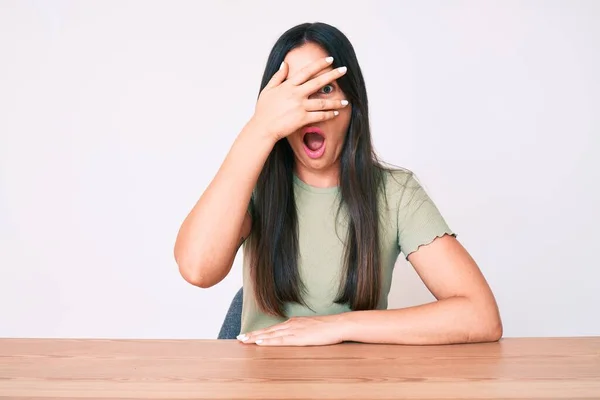 Mujer Caucásica Joven Sentada Mesa Con Ropa Casual Asomándose Shock — Foto de Stock