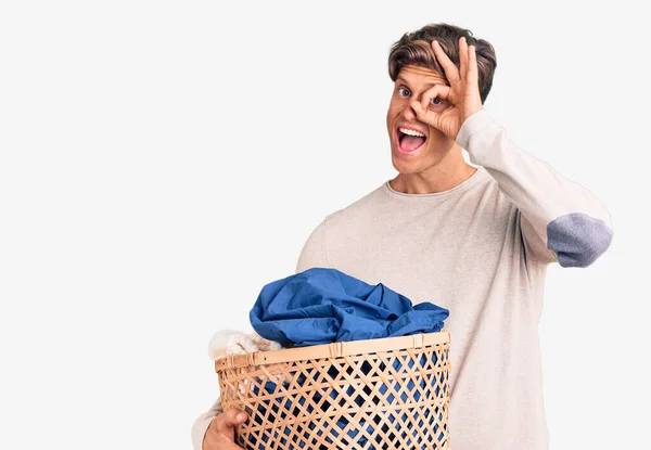 Joven Hombre Guapo Sosteniendo Cesta Ropa Sonriendo Feliz Haciendo Signo — Foto de Stock