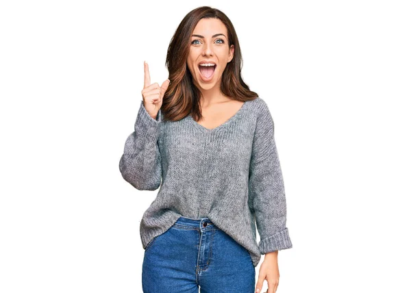 若いブルネットの女性は 成功したアイデアで指を指してカジュアルな冬のセーターを着ています 興奮して幸せよ 第1位 — ストック写真