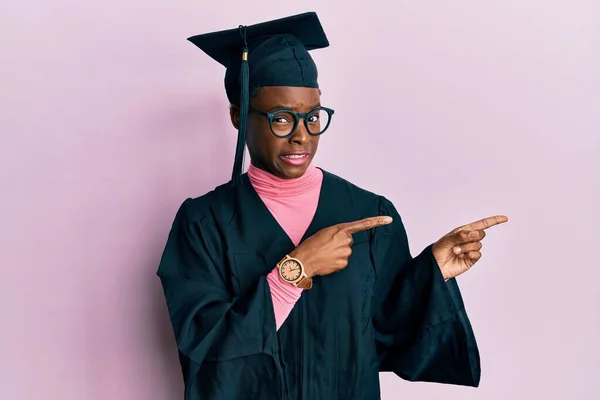 Νεαρή Αφροαμερικανή Που Φοράει Καπέλο Αποφοίτησης Και Επίσημη Ρόμπα Δείχνοντας — Φωτογραφία Αρχείου