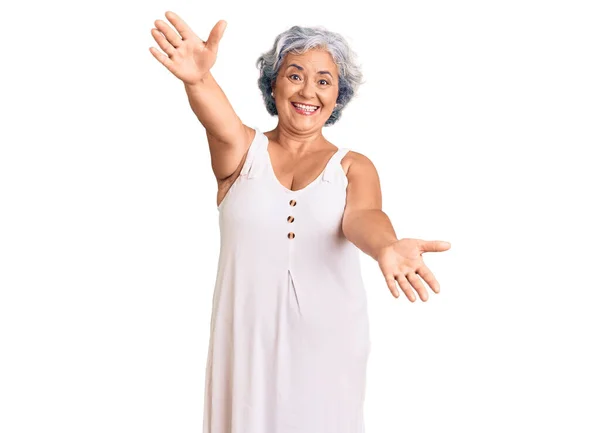 白发苍苍的老妇人穿着休闲装 看着相机 张开双臂拥抱 欢快的表达拥抱幸福 — 图库照片