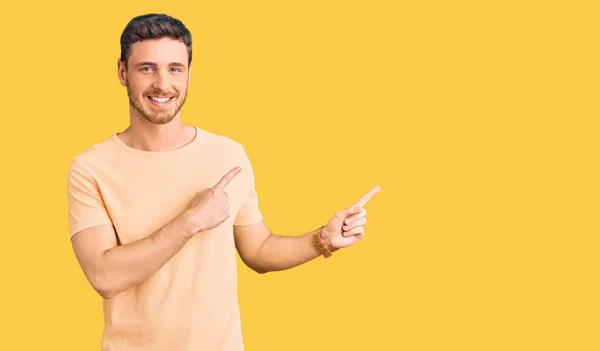 Sarı Tişörtlü Yakışıklı Genç Adam Gülümsüyor Kameraya Bakıyor Iki Eliyle — Stok fotoğraf