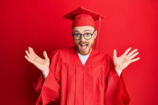 Νεαρός Κοκκινομάλλης Κόκκινο Καπέλο Αποφοίτησης Και Επίσημη Ρόμπα Γιορτάζει Τρελός — Φωτογραφία Αρχείου