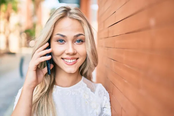Jovem Caucasiana Sorrindo Feliz Falando Smartphone Encostado Parede — Fotografia de Stock