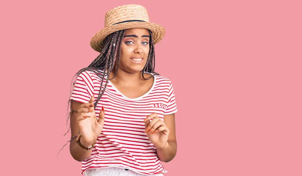 头戴夏帽 头戴辫子的年轻非洲裔美国女人厌恶表情 因为厌恶的反应而不高兴 害怕做厌恶的表情 — 图库照片