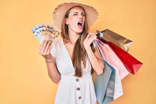 Young Blonde Girl Holding Shopping Bags Canadian Dollars Angry Mad — Stock Photo, Image