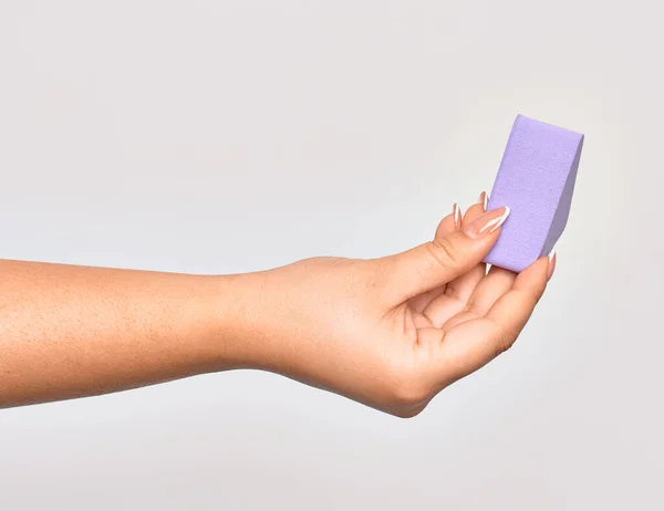 白地に紫色の化粧スポンジを持つ白人の若い女性の手 — ストック写真