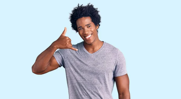 英俊的非洲裔美国男人 留着黑发 穿着休闲装 微笑着用手和手指做电话手势 就像在电话里说话一样 交流概念 — 图库照片