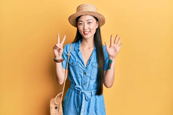 年轻的中国女人头戴夏帽 头戴七号手指 面带微笑 自信而快乐 — 图库照片