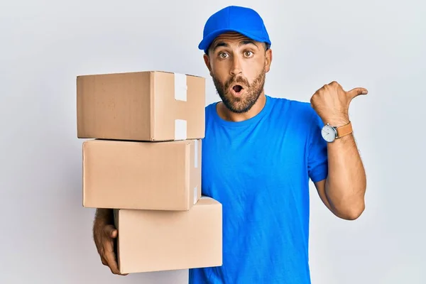 Handsome Man Beard Wearing Courier Uniform Holding Delivery Packages Surprised — Stock Photo, Image