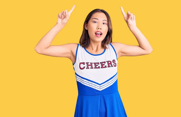Młoda Piękna Chińska Dziewczyna Mundurze Cheerleaderki Uśmiechnięta Zdumiona Zaskoczona Wskazująca — Zdjęcie stockowe