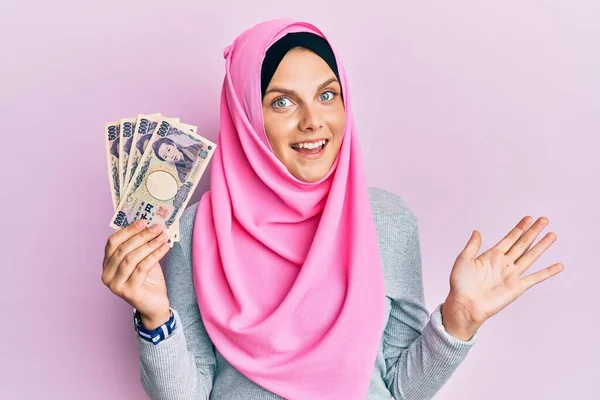 Νεαρή Καυκάσια Γυναίκα Φορώντας Ισλαμική Μαντίλα Κρατώντας Γιαπωνέζικα Χαρτονομίσματα Γιεν — Φωτογραφία Αρχείου