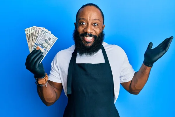 Young African American Man Wearing Professional Apron Holding Usa Dollars — Stock Photo, Image