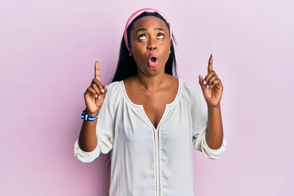 Jonge Afrikaanse Vrouw Draagt Casual Kleding Roze Achtergrond Verbaasd Verrast — Stockfoto