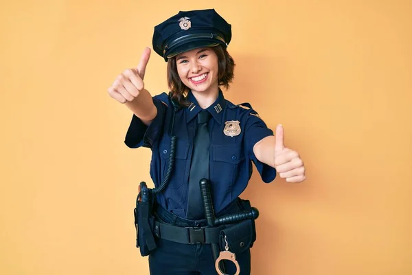 警察の制服を着た若い美しい女性は 手で積極的なジェスチャーを行うことを承認します 親指アップ笑顔と成功のために幸せ 勝者のジェスチャー — ストック写真