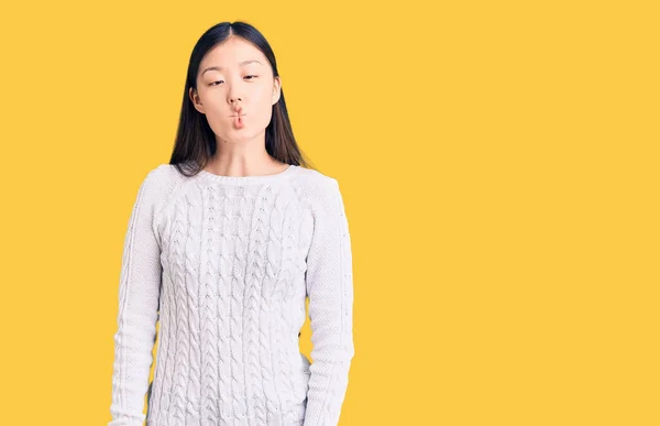 狂気とコミカルなジェスチャーで魚の顔を作るカジュアルなセーターを着て若い美しい中国の女性 面白い表現 — ストック写真