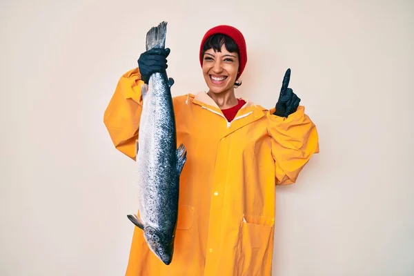 Hermosa Mujer Pescadora Morena Con Impermeable Sosteniendo Salmón Fresco Sorprendida —  Fotos de Stock