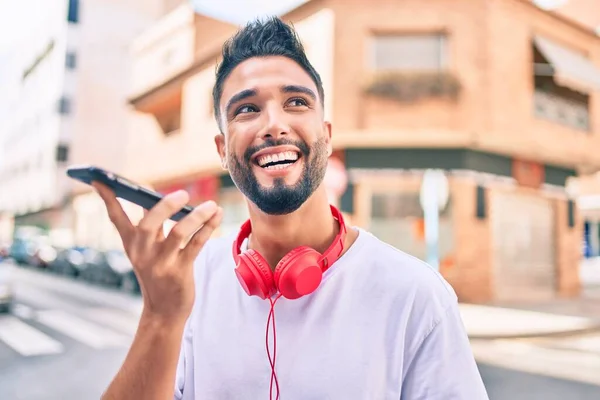若いアラブ人の男笑顔幸せな送信音声メッセージを使用してスマートフォンで市内 — ストック写真