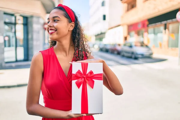 Jovem Menina Afro Americana Sorrindo Feliz Segurando Caixa Presente Cidade — Fotografia de Stock