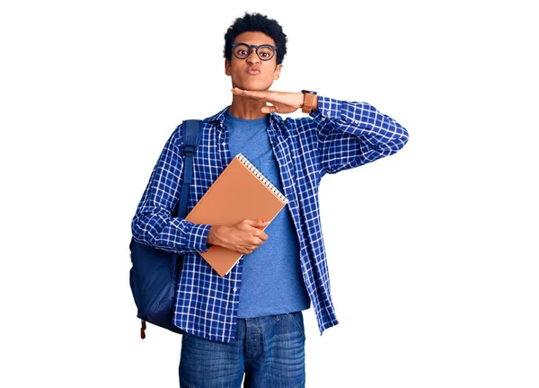 Genç Afro-Amerikalı bir adam sırt çantası takıyor. Kitabı tutuyor. Elinde bıçakla boğazını kesiyor. 