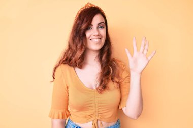 Genç ve güzel bir kadın gündelik giysiler giyer ve beş numarayı göstererek gülümserken kendinden emin ve mutlu görünürdü.. 