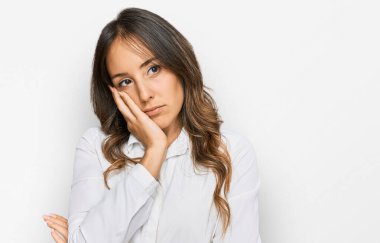 Genç esmer kadın gündelik kıyafetler giyip kollarını kavuşturarak depresyondan sıkılmış ve yorgun görünüyor.. 