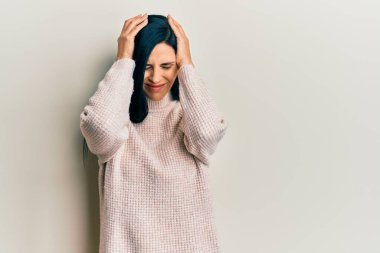 Kafkasyalı genç bir kadın günlük kazak giyiyor. Baş ağrısı çekiyor. Acı ve migren yüzünden çaresiz ve stresli. Eller başının üstünde.. 