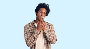 Yakışıklı Afro saçlı, sıradan kıyafetler ve gözlük takan, el hareketleriyle sembolik silah tutan, cinayet silahlarıyla oynayan, kızgın yüzlü Afro-Amerikan erkeği. 