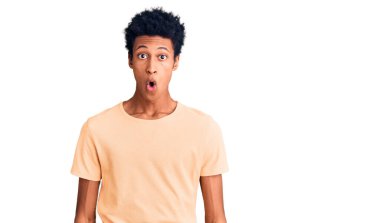 Genç Afro-Amerikan adam günlük kıyafetler giyiyor. Şaşırtıcı bir ifade, korku ve heyecan dolu bir yüz ifadesi var.. 