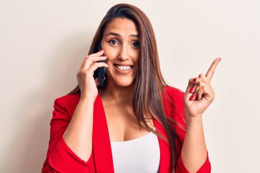 Genç, güzel, esmer bir kadın akıllı telefondan konuşuyor. Gülümsüyor, mutlu bir şekilde elini ve parmağını yana uzatıyordu. 