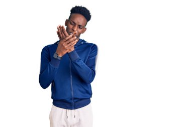 Genç Afro-Amerikan erkek spor giysisi giyiyor. Ellerinde ve parmaklarında ağrı var. Eklem iltihabı. 