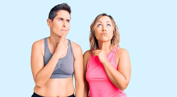 Couple Women Wearing Sportswear Thinking Concentrated Doubt Finger Chin Looking — Stock Photo, Image