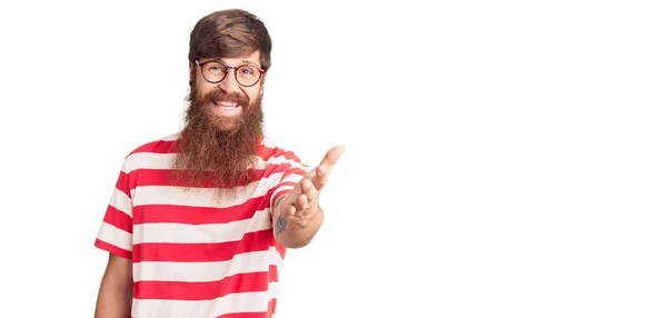 英俊的红头发男子 留着长胡子 穿着休闲装 面带微笑 友善地握手致意和欢迎 成功的商业 — 图库照片