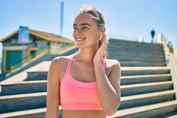 Jonge Blonde Sportvrouw Met Behulp Van Oortelefoons Doen Oefening Stad — Stockfoto