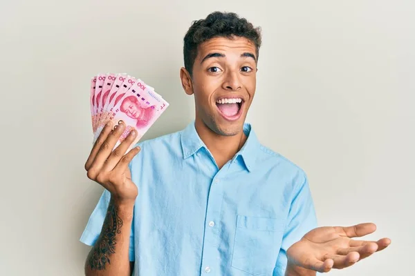 Joven Hombre Afroamericano Guapo Sosteniendo Billetes Chinos 100 Yuanes Celebrando —  Fotos de Stock