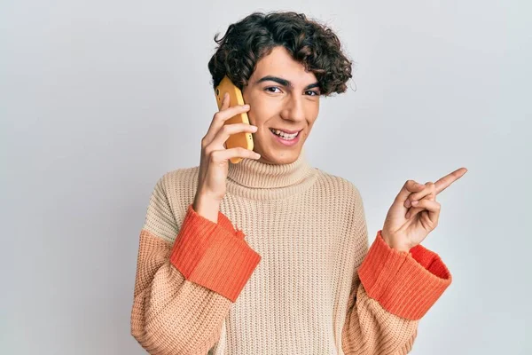 Jovem Hispânico Conversando Smartphone Sorrindo Feliz Apontando Com Mão Dedo — Fotografia de Stock