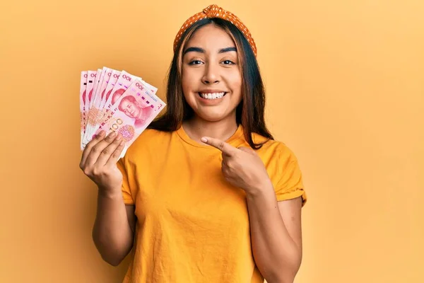Mladá Latinská Žena Drží Čínské Bankovky Úsměvem Šťastný Ukazující Rukou — Stock fotografie