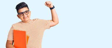 Küçük çocuk kitap tutuyor, gözlük takıyor güçlü, kol kaslı, kendinden emin ve gururlu. 