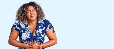 Genç Afro-Amerikan artı cüsseli kadın elleri karnında günlük kıyafetler giyiyor çünkü mide bulantısı, acı verici bir hastalık kendini iyi hissetmiyor. Ağrı kavramı. 