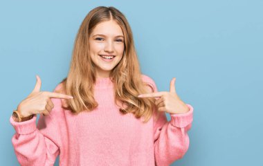 Güzel, genç, beyaz, sıradan bir süveter giyen, kendine güveni olan, kendini gururlu ve mutlu gösteren bir kız.. 