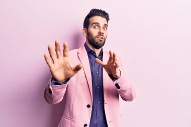 Sakallı, zarif ceketli, korku ifadesinden korkmuş ve dehşete düşmüş genç yakışıklı bir adam. El kol hareketi yapmayı kes, şok içinde bağır. panik konsepti. 