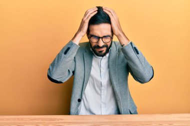 Ofiste çalışan genç İspanyol bir adam baş ağrısı çekiyor. Acı ve migren yüzünden çaresiz ve stresli. Eller başının üstünde.. 