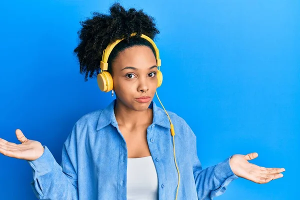Chica Afroamericana Joven Escuchando Música Usando Auriculares Expresión Despistada Confusa — Foto de Stock