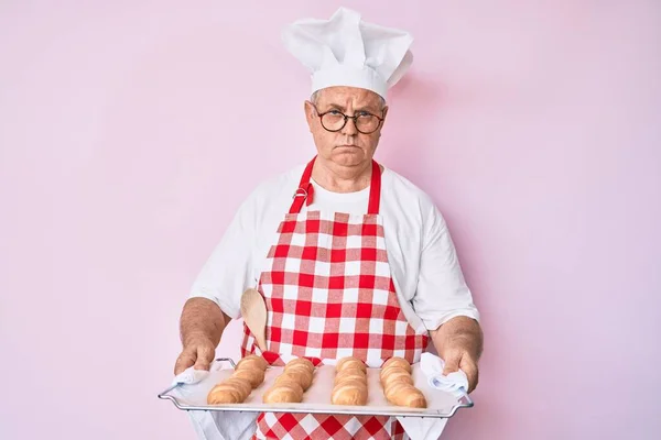 Senior Gråhårig Man Bagaruniform Med Hembakat Bröd Skeptisk Och Nervös — Stockfoto