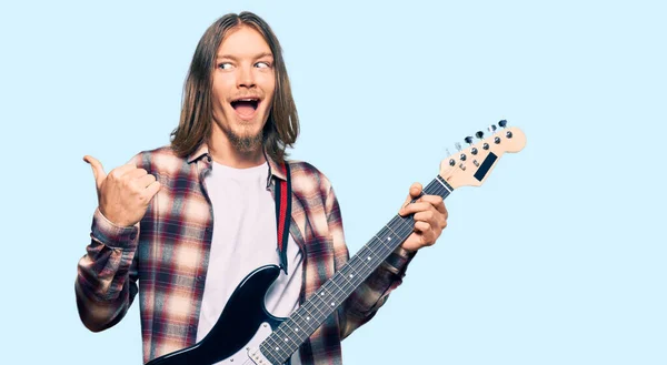 Handsome Caucasian Man Long Hair Playing Electric Guitar Pointing Thumb — Stock Photo, Image
