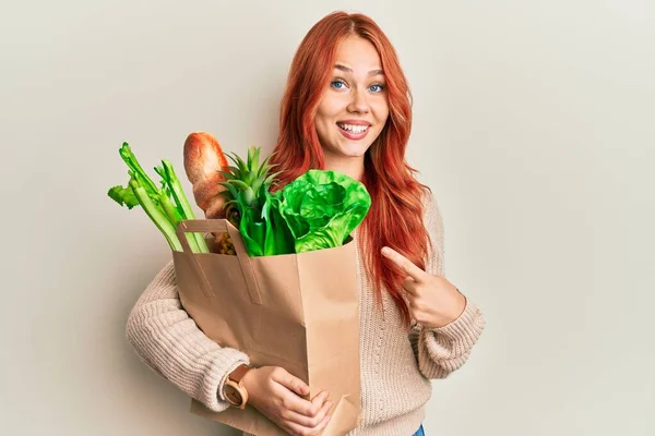 Ung Rödhårig Kvinna Som Håller Papperspåse Med Bröd Och Matvaror — Stockfoto