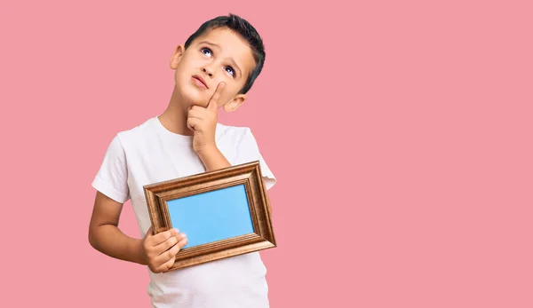 Little Cute Boy Kid Holding Empty Frame Serious Face Thinking — Foto de Stock