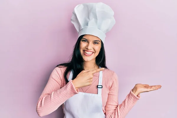 Νεαρή Ισπανίδα Γυναίκα Φορώντας Στολή Φούρναρη Και Μαγειρεύουν Καπέλο Κατάπληκτος — Φωτογραφία Αρχείου