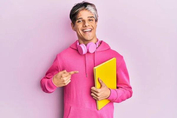 Jovem Hispânico Homem Segurando Livro Usando Fones Ouvido Sorrindo Feliz — Fotografia de Stock